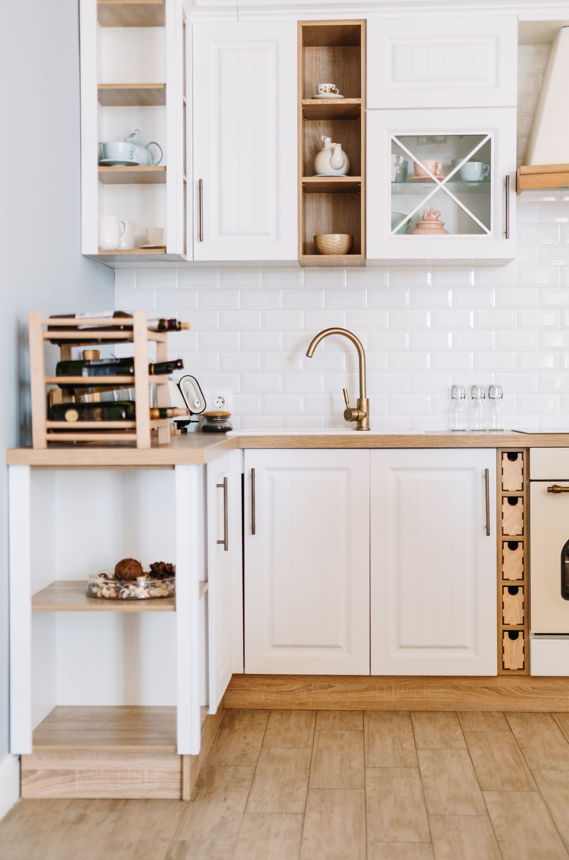 White kitchen with light wood accents and a wine rack on the counter.