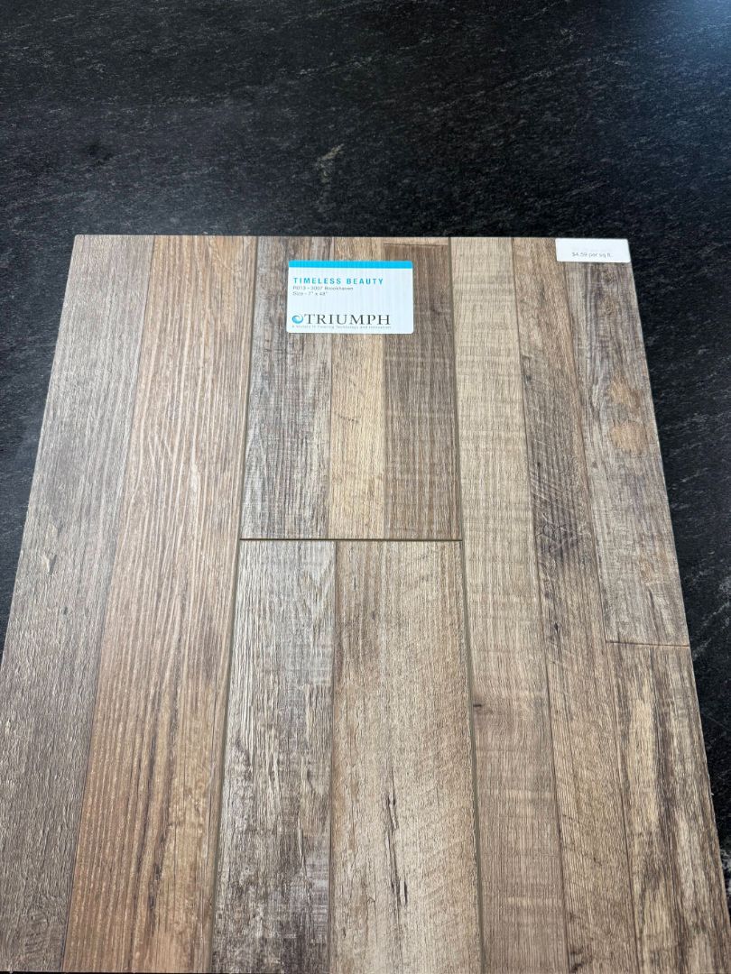 Wooden floorboard sample with various shades of brown and a label in the center.