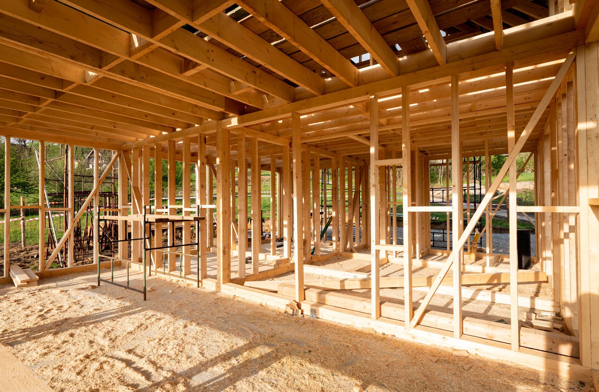 Wooden framework of a building under construction, with beams and studs visible.