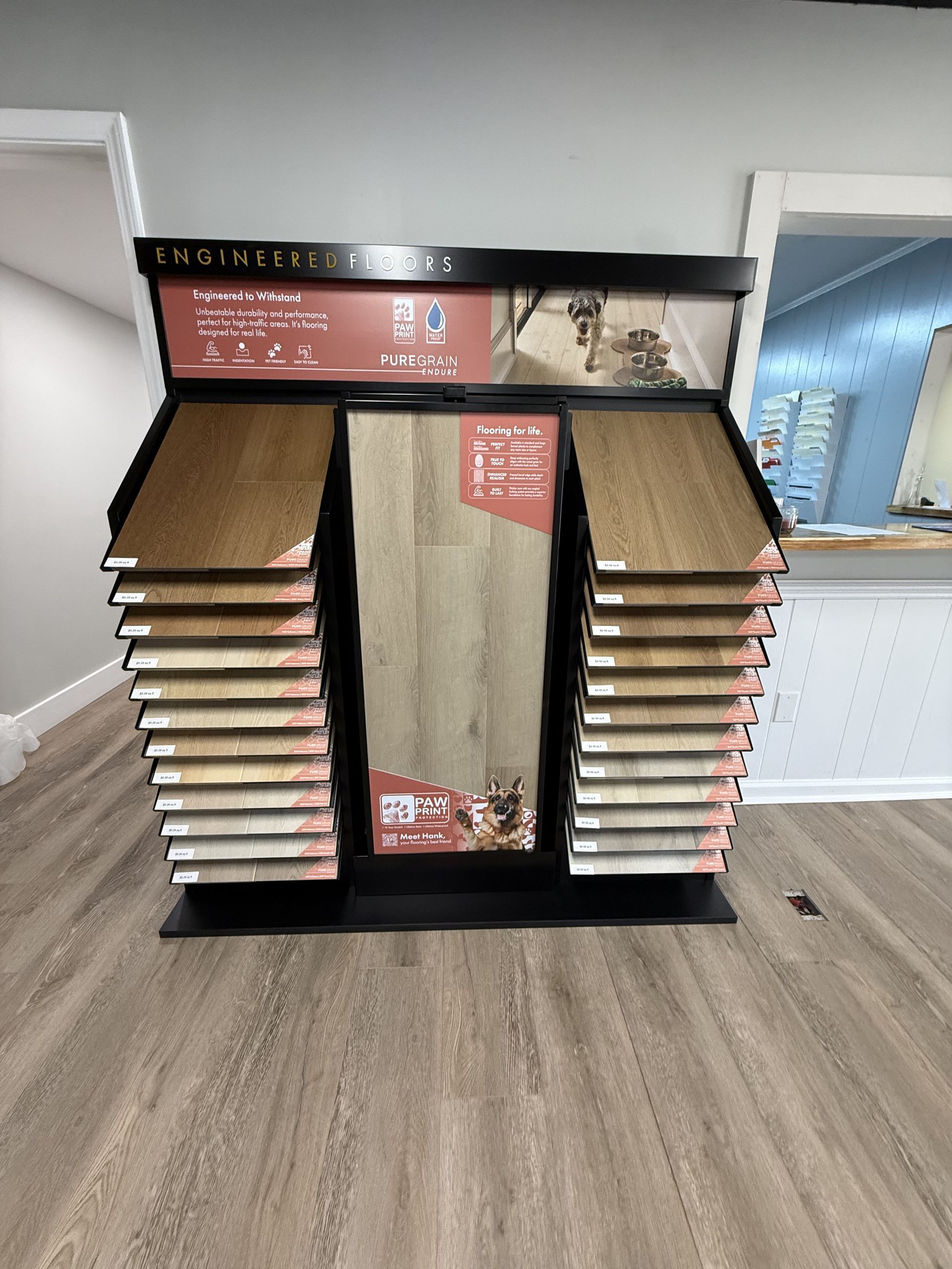 Flooring display with various wood and stone samples in a showroom.