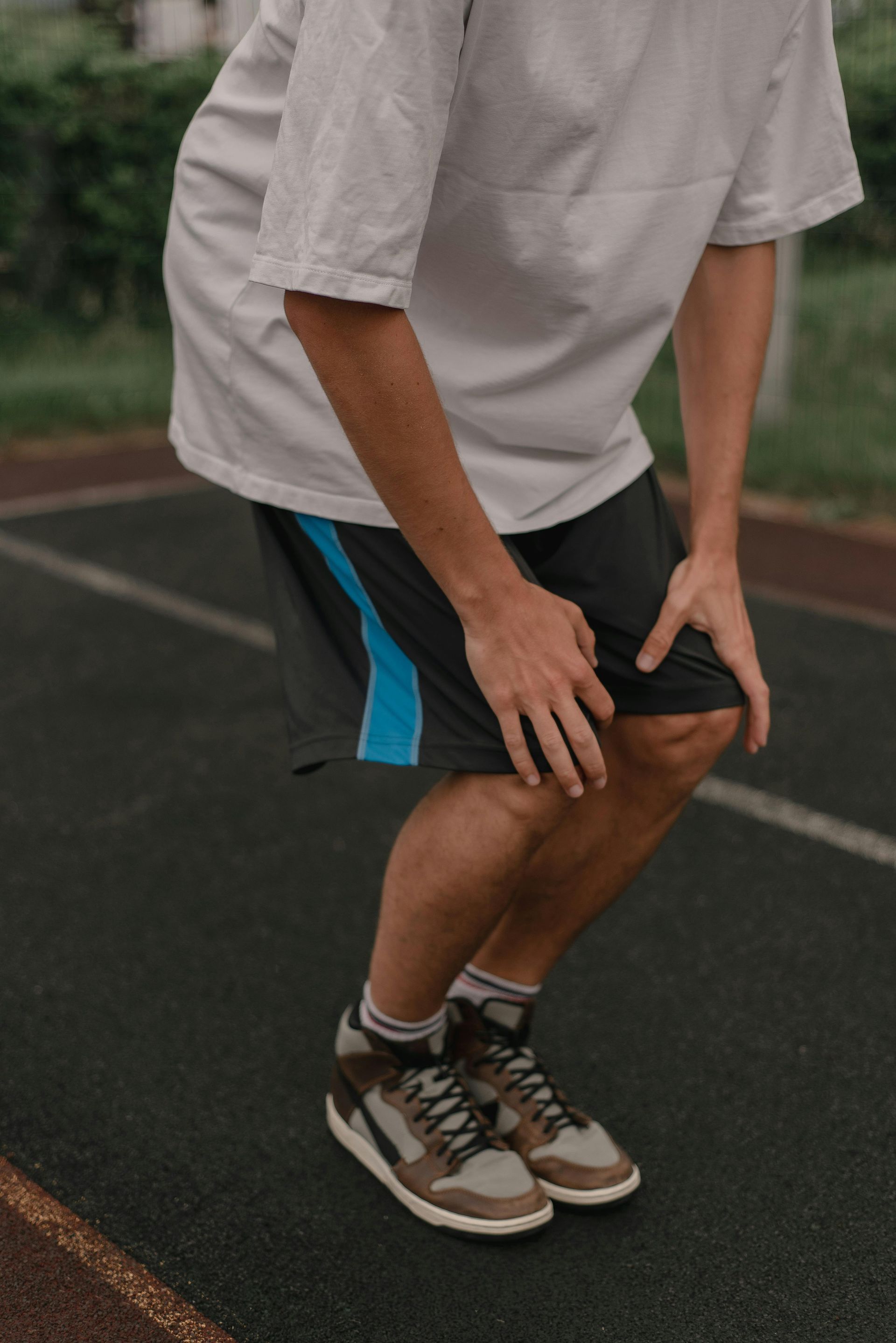 person clutching knees in pain after a run
