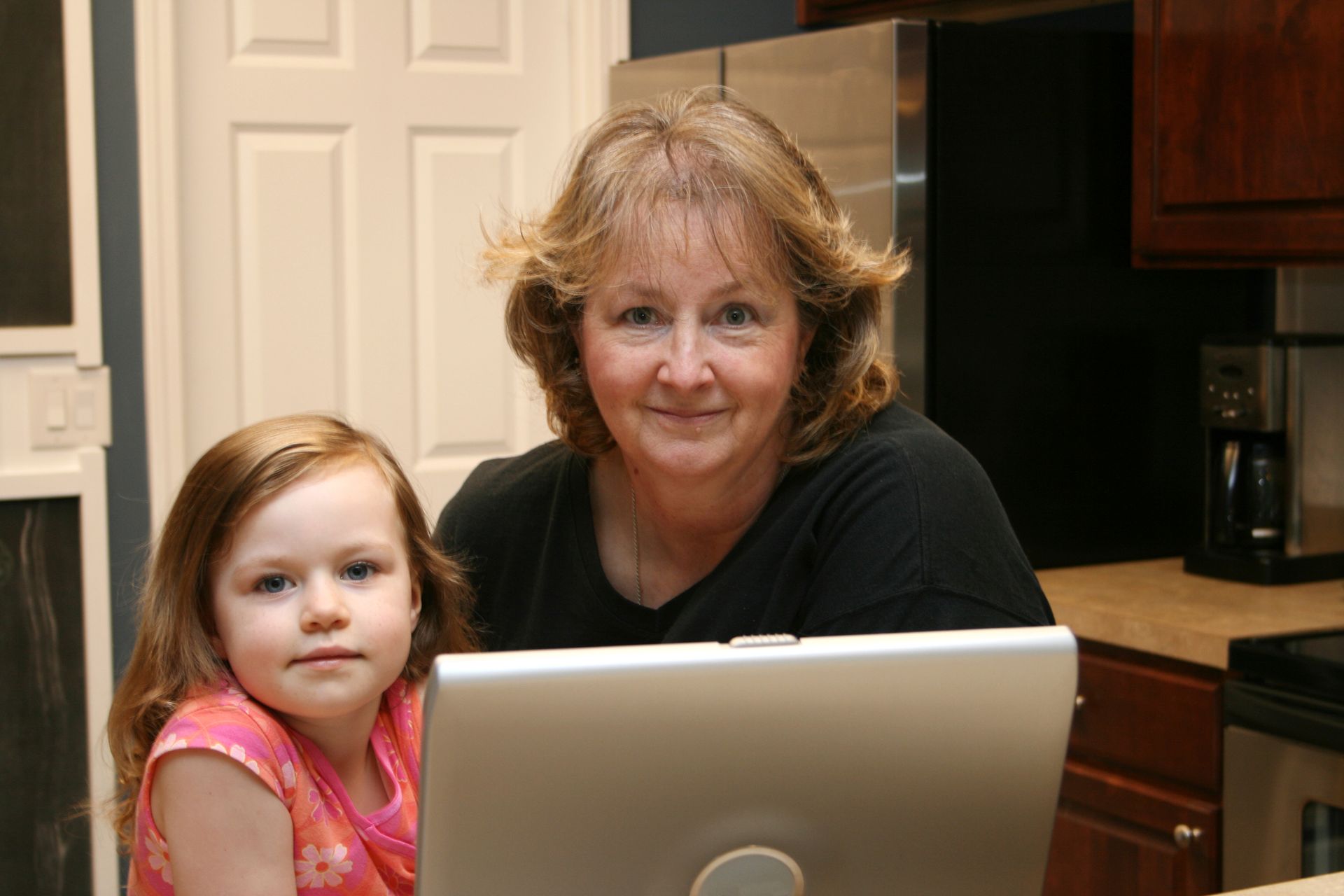 A grandmother and her granddaughter on the computer together.