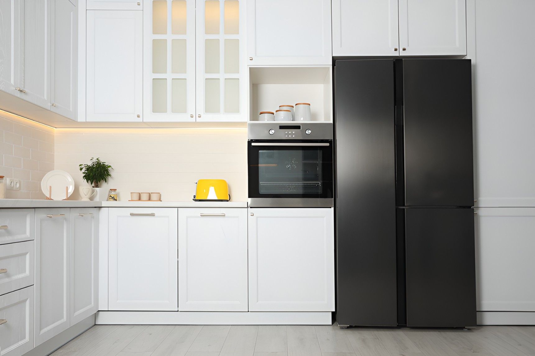 A Kitchen With White Cabinets and a Black Refrigerator — Cooling Plus Refrigeration & Airconditioning in Ciccone, NT