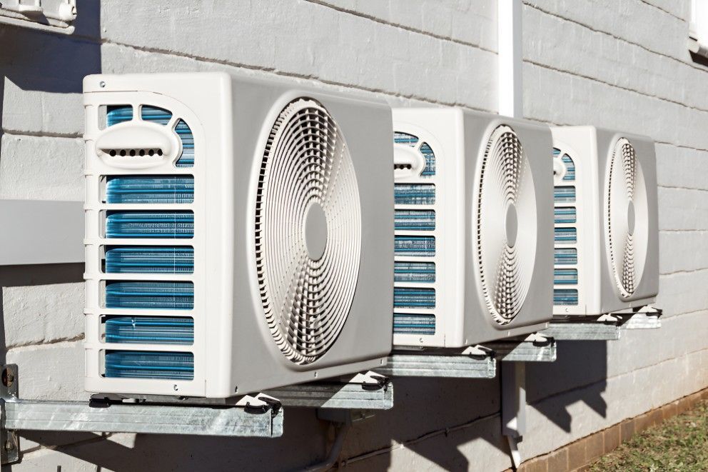 A Row of Air Conditioners on the Side of a Building — Cooling Plus Refrigeration & Airconditioning in Ciccone, NT