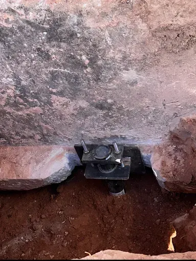 Steel pier support installed in trench under foundation.