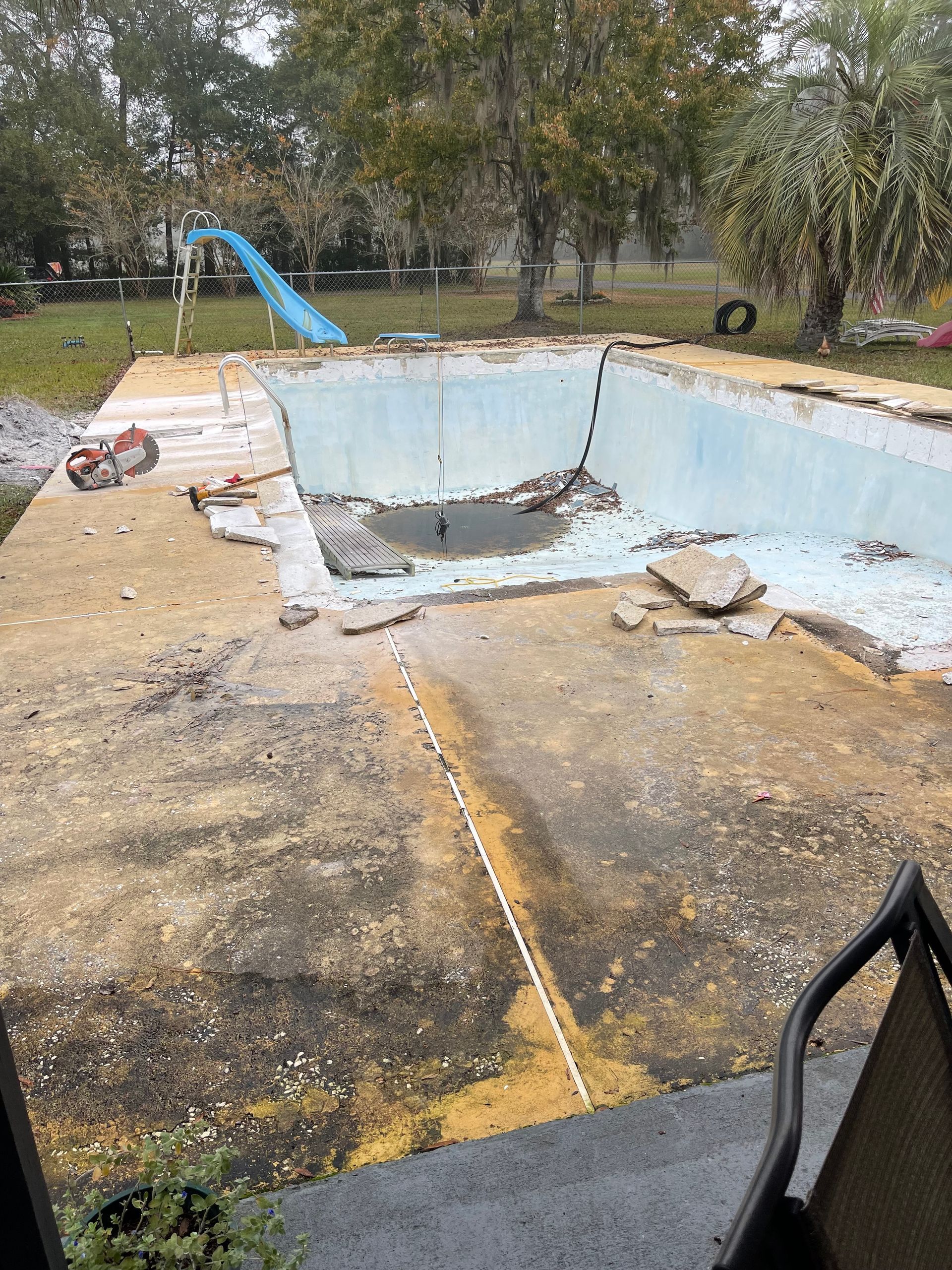 A swimming pool is being remodeled in a backyard.