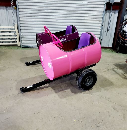 A pink barrel with purple seats and a steering wheel