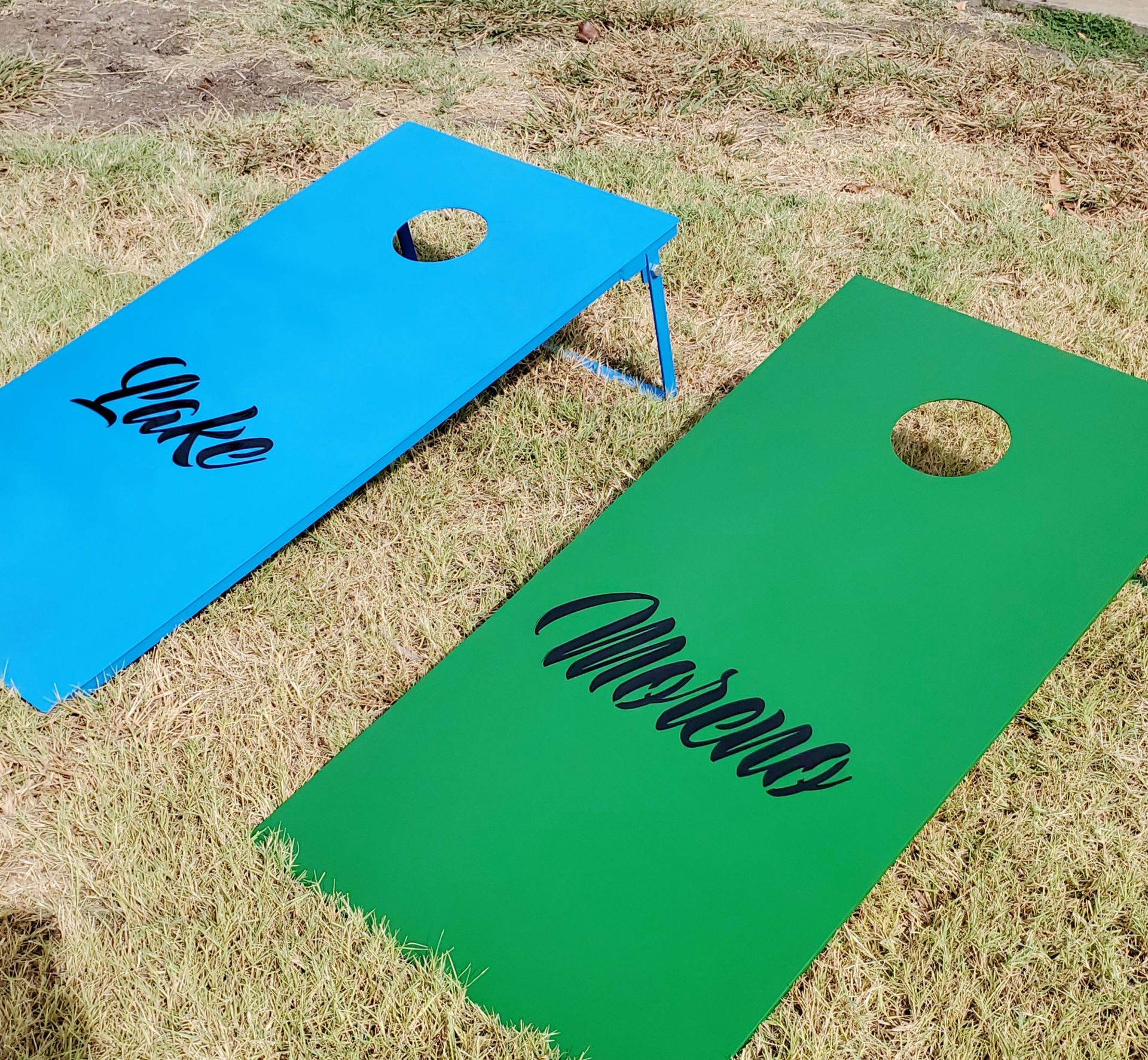 Two cornhole boards with the names luke and andrew on them