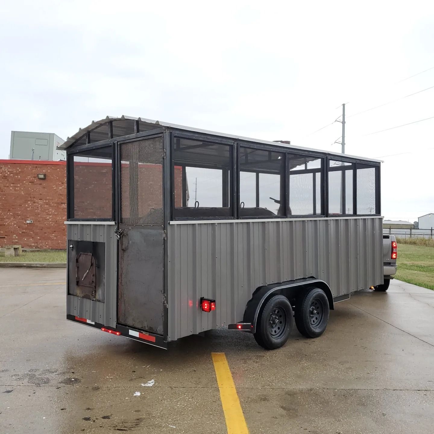 A trailer is parked in a parking lot next to a truck.