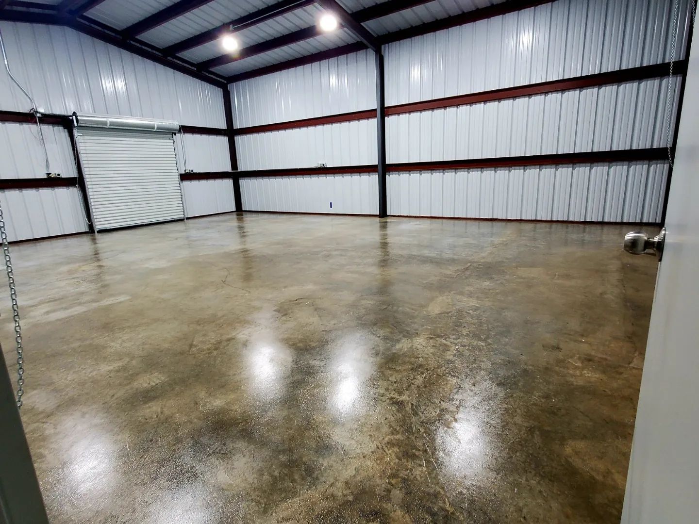 A large empty warehouse with a concrete floor and white walls.