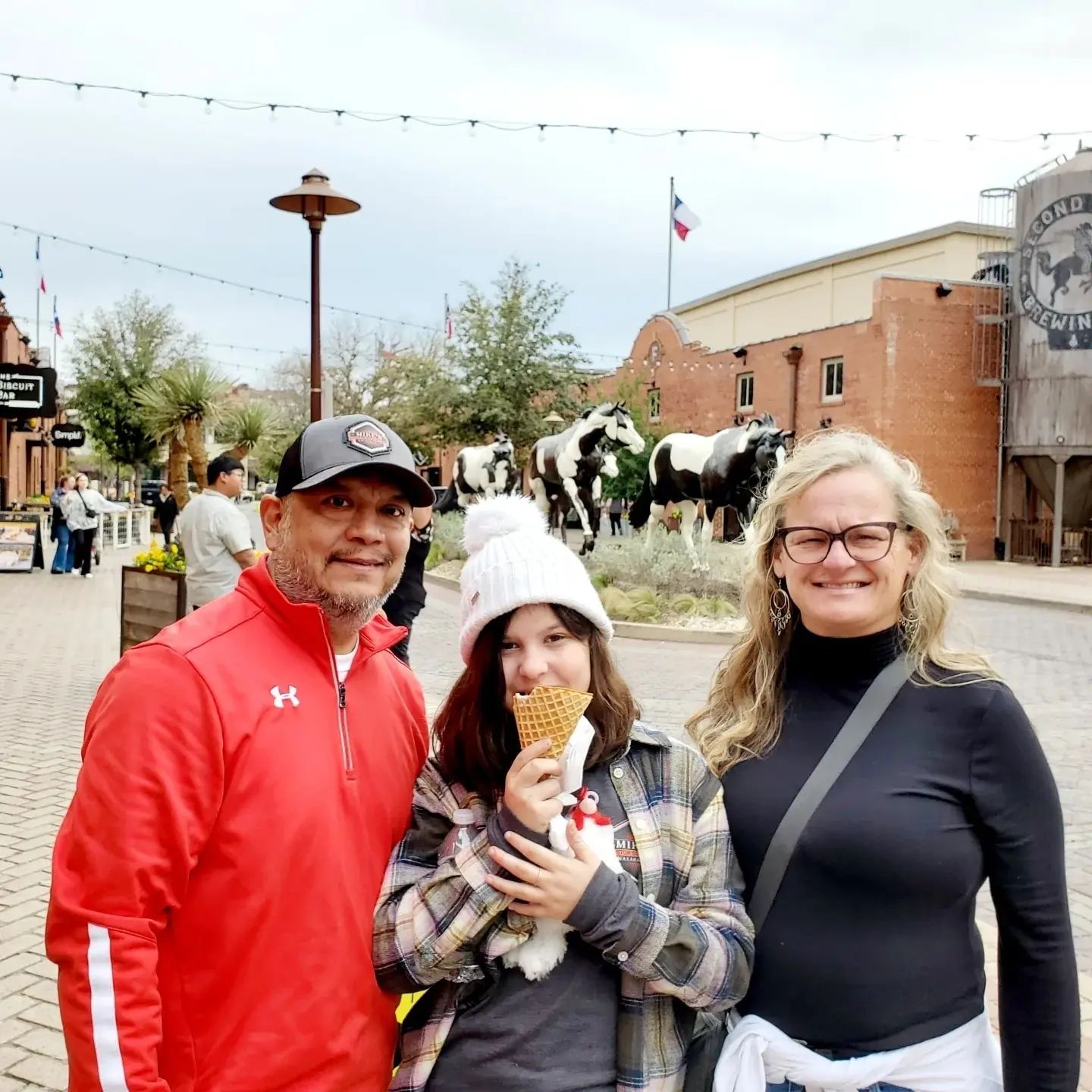 A group of people are posing for a picture in front of a cow statue.
