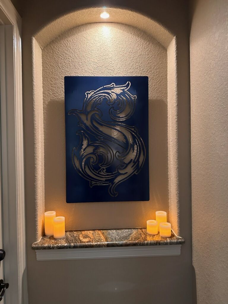 A painting of a dragon is hanging on a wall next to candles.