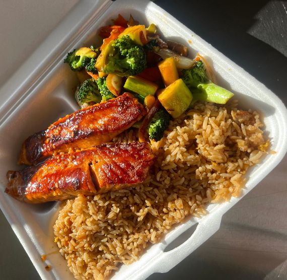 A styrofoam container filled with rice and meat and vegetables