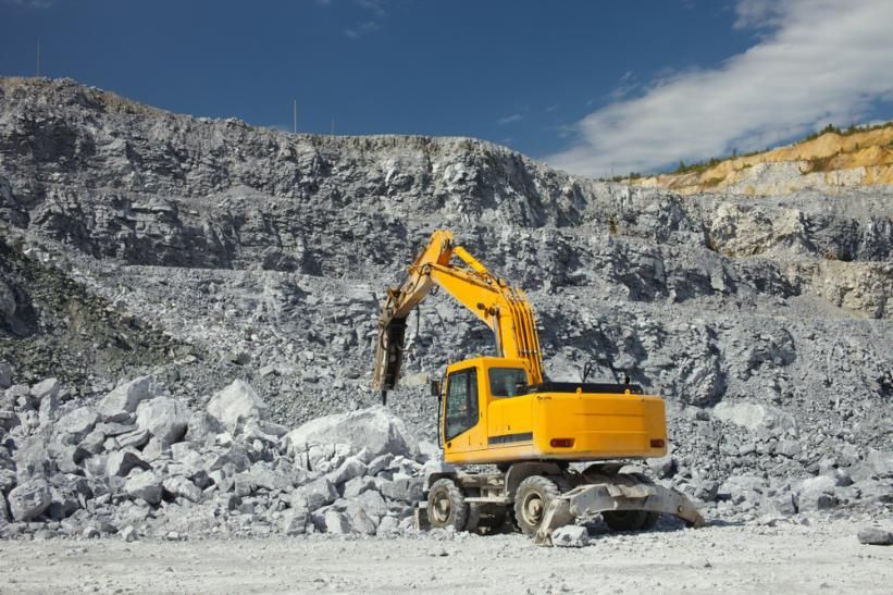A Yellow Excavator is Working in a Rock Quarry — Zappala Quarries in Cairns, QLD