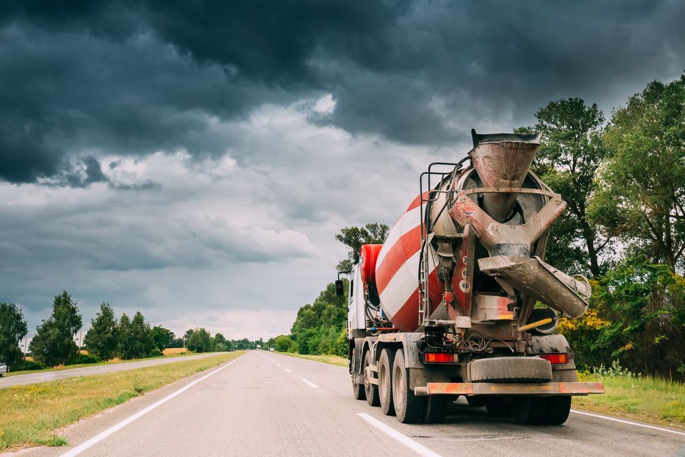 Cement Truck on A Paved Road Under a Cloudy, Overcast Sky, Trees in The Background — Zappala Quarries in Gordonvale, QLD