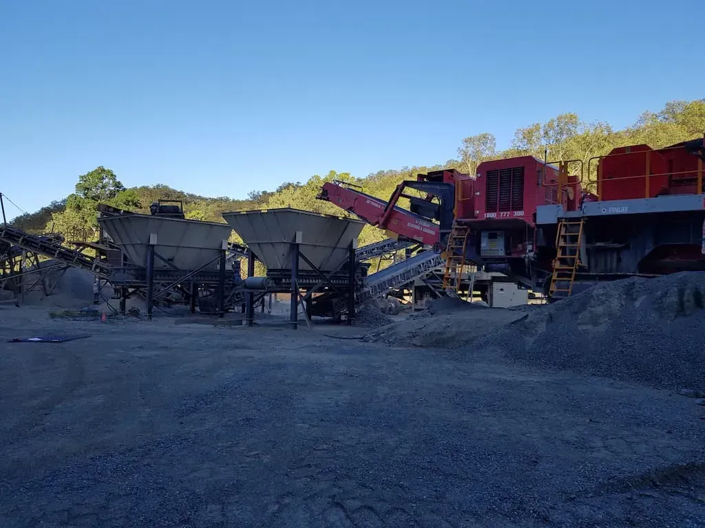 A Large Red Machine Is Sitting in The Middle of A Dirt Field — Zappala Quarries in Gordonvale, QLD