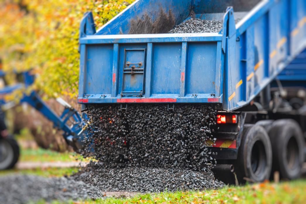 A Blue Dump Truck is Being Loaded With Gravel — Zappala Quarries in Innisfail, QLD