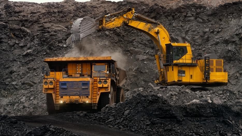 A Yellow Excavator is Loading Coal Into a Dump Truck in a Coal Mine — Zappala Quarries in Cairns, QLD