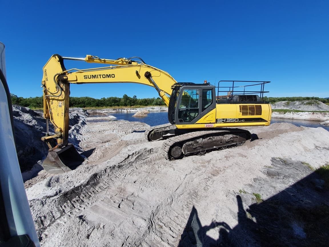 A Yellow Excavator Is Digging in A Pile of Sand — Zappala Quarries in Gordonvale, QLD