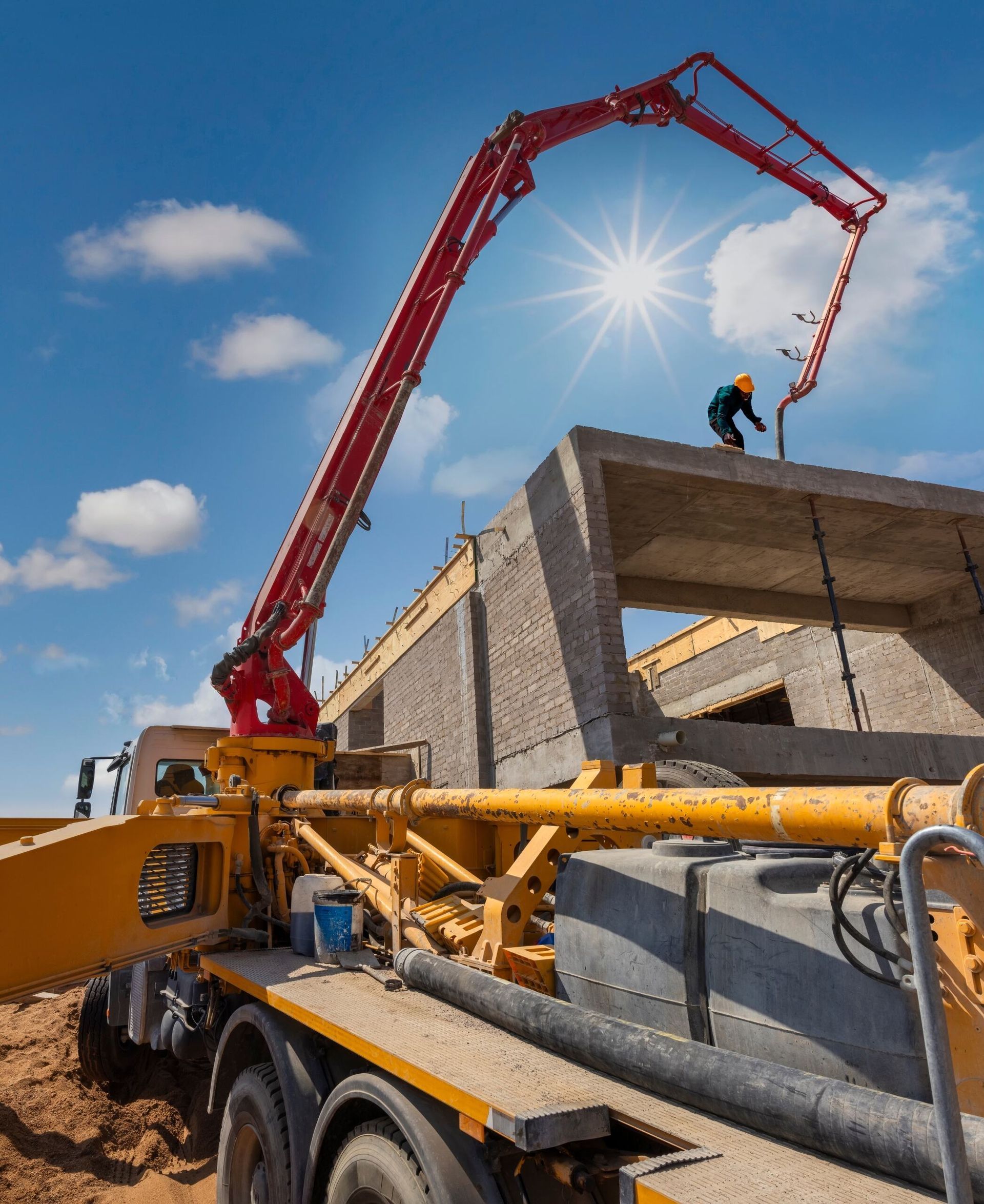 Construction Worker Operating Concrete Pump Pouring Concrete onto A Building Frame Under a Bright Sun — Zappala Quarries in Douglas Shire, QLD