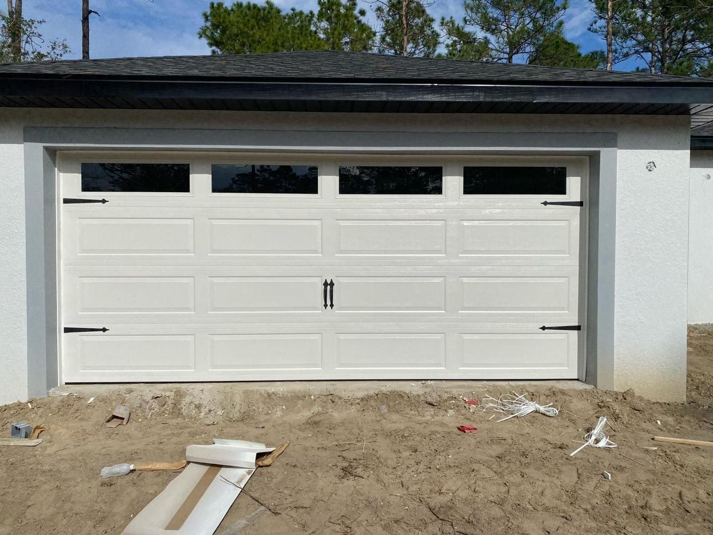 A white garage door is being installed on a house