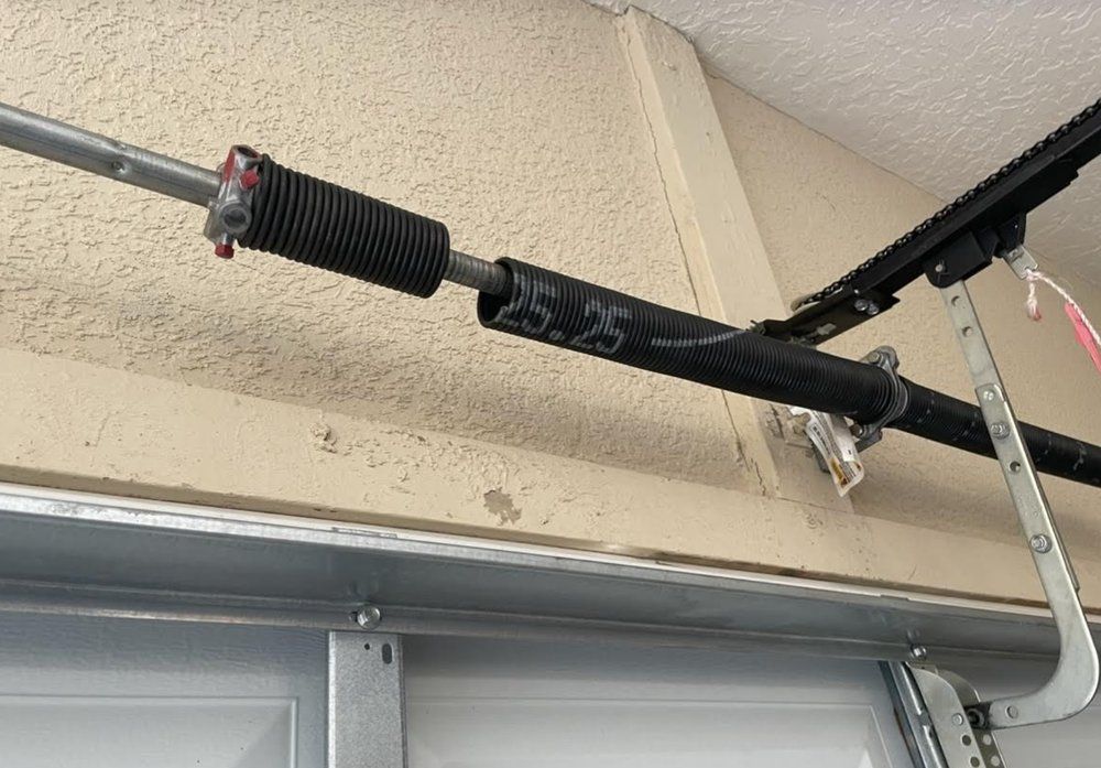 A close up of a garage door spring on a garage door.