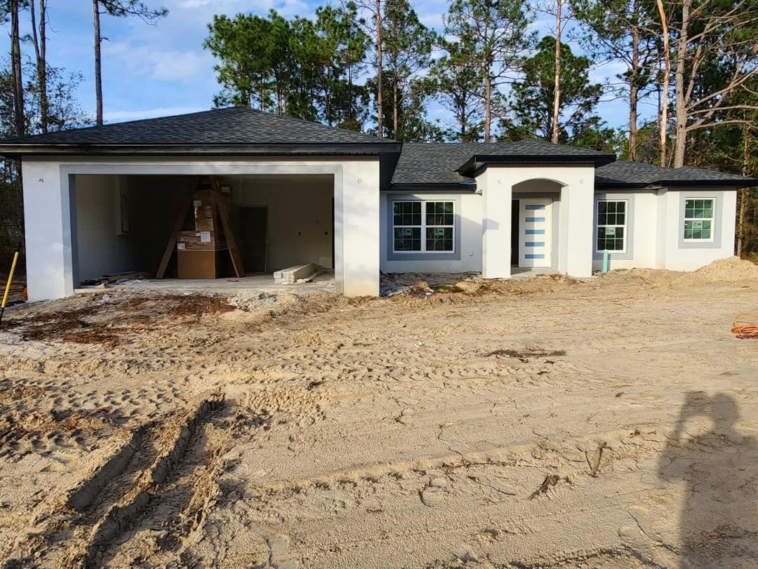 A house is being built in the middle of a dirt field.