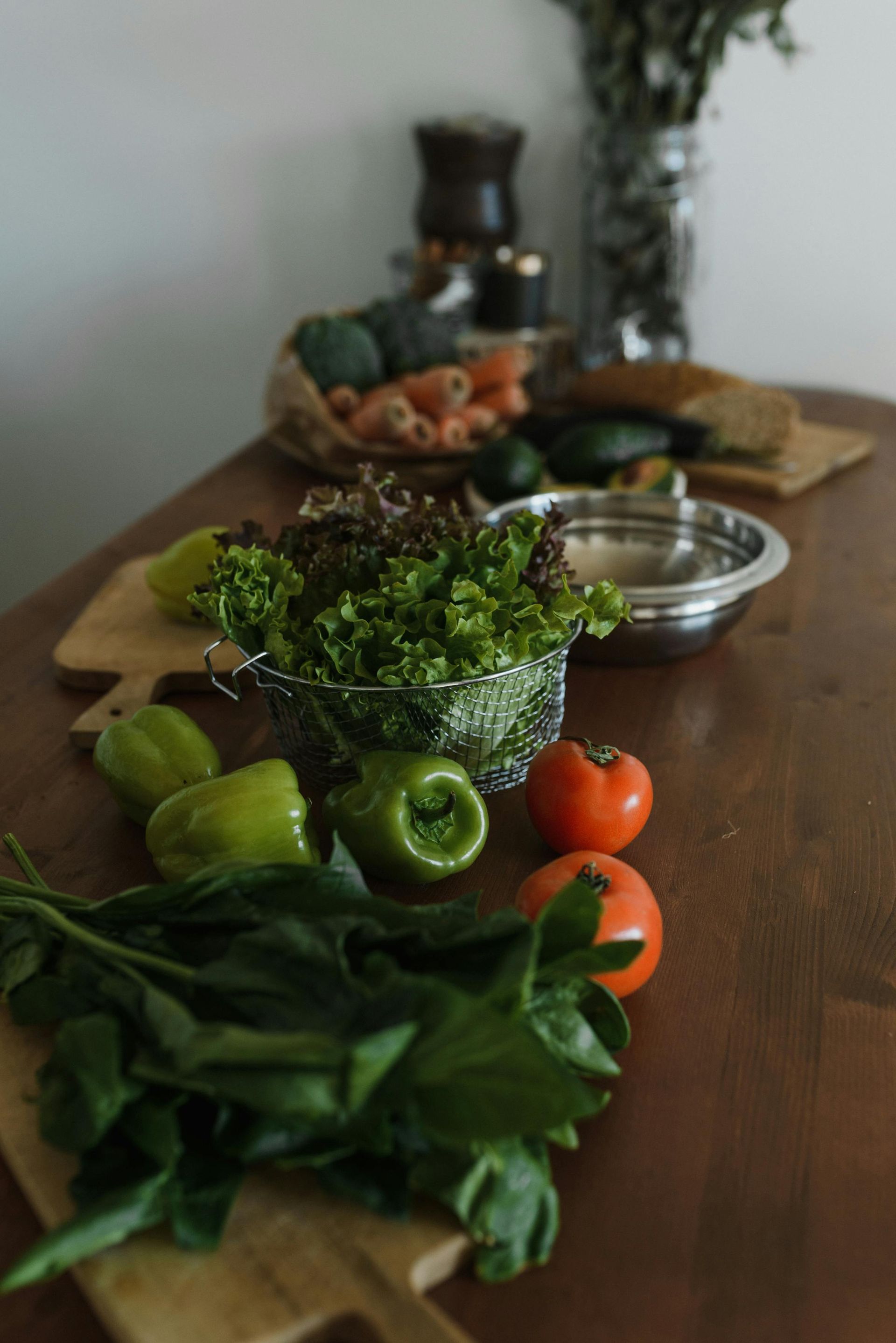 A wooden plate with a salad bowl, hard-boiled eggs, cherry tomatoes, grapefruit slices, and fresh dark cherries.