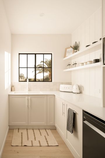 A Kitchen With Large Window and cream cabinets — Halls Cabinets & Joinery in Harlaxton, QLD