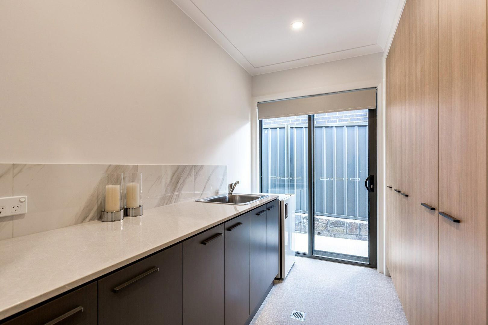 A Laundry Room With a Washer and Dryer, Sink, and Mirror — Halls Cabinets & Joinery in Harlaxton, QLD