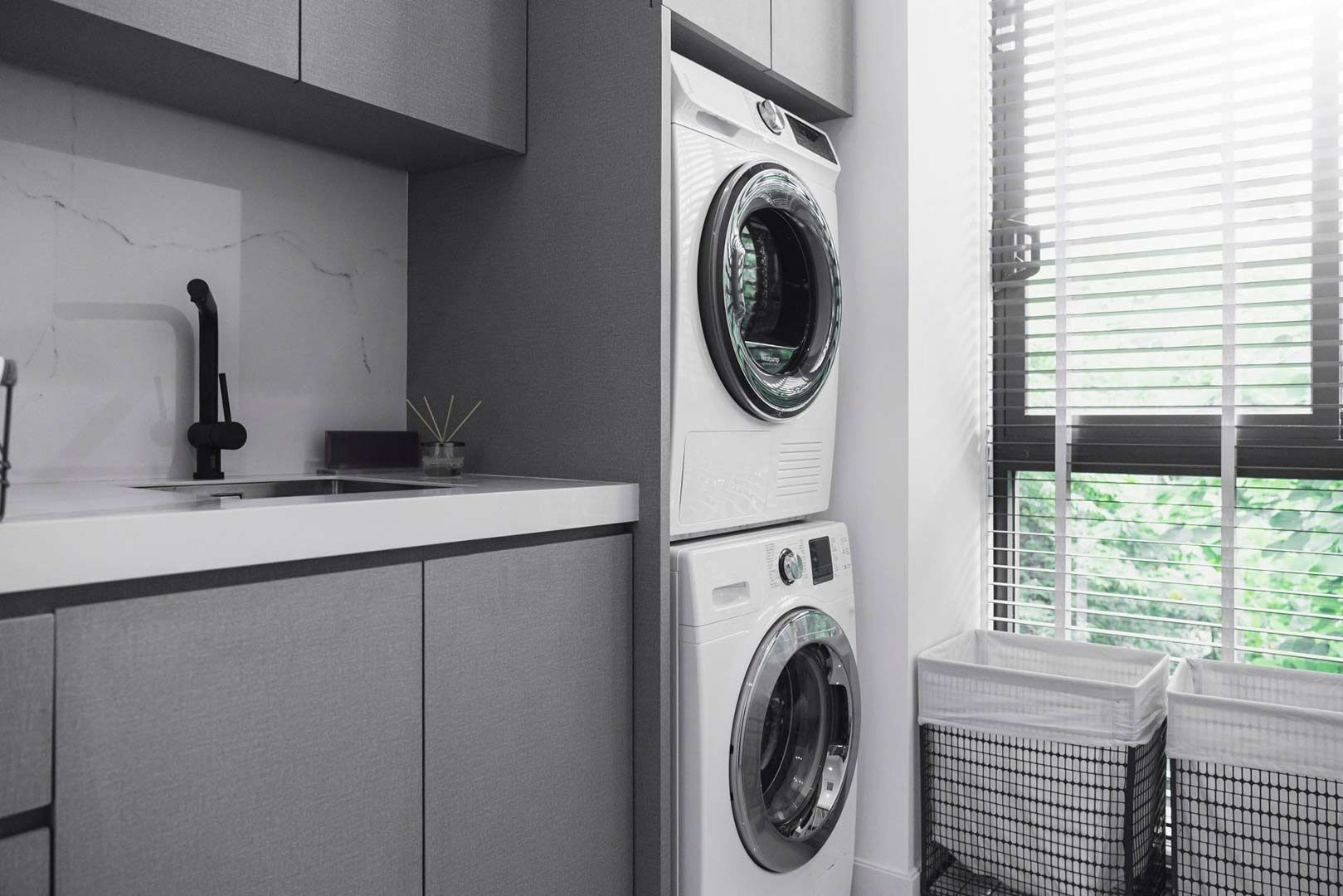 A Laundry Room With a Washer and Dryer Stacked on Top of Each Other — Halls Cabinets & Joinery in Harlaxton, QLD