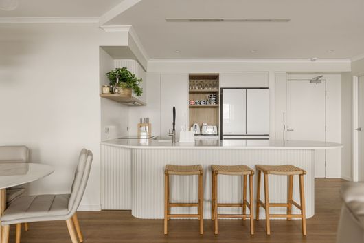 A Kitchen With a Large Island and Three Stools — Halls Cabinets & Joinery in Harlaxton, QLD