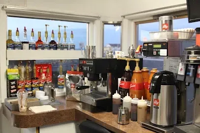 A kitchen with a lot of bottles and a coffee machine.