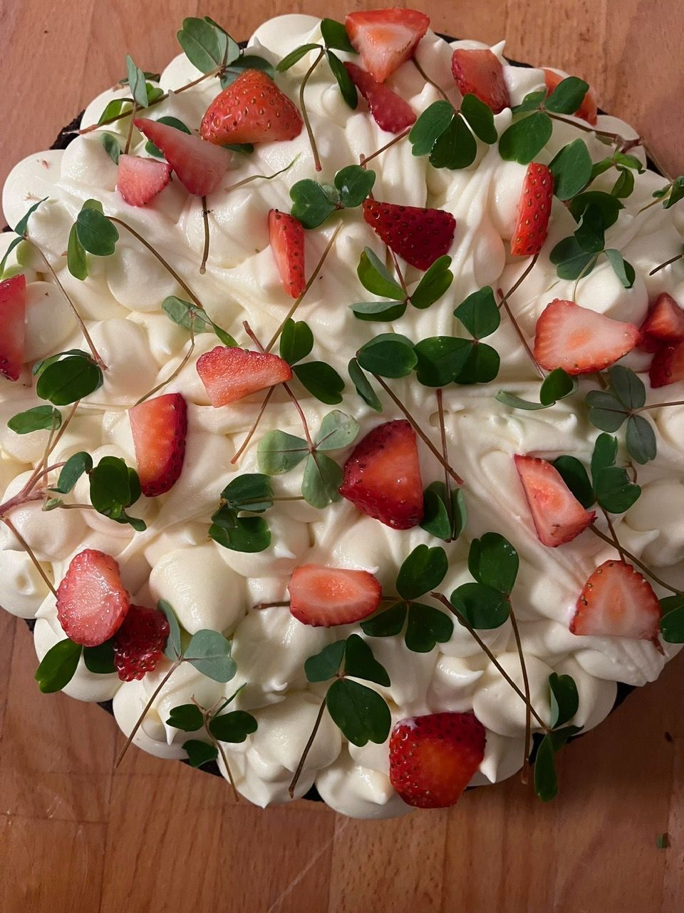 En kage med flødeskum og jordbær på toppen.