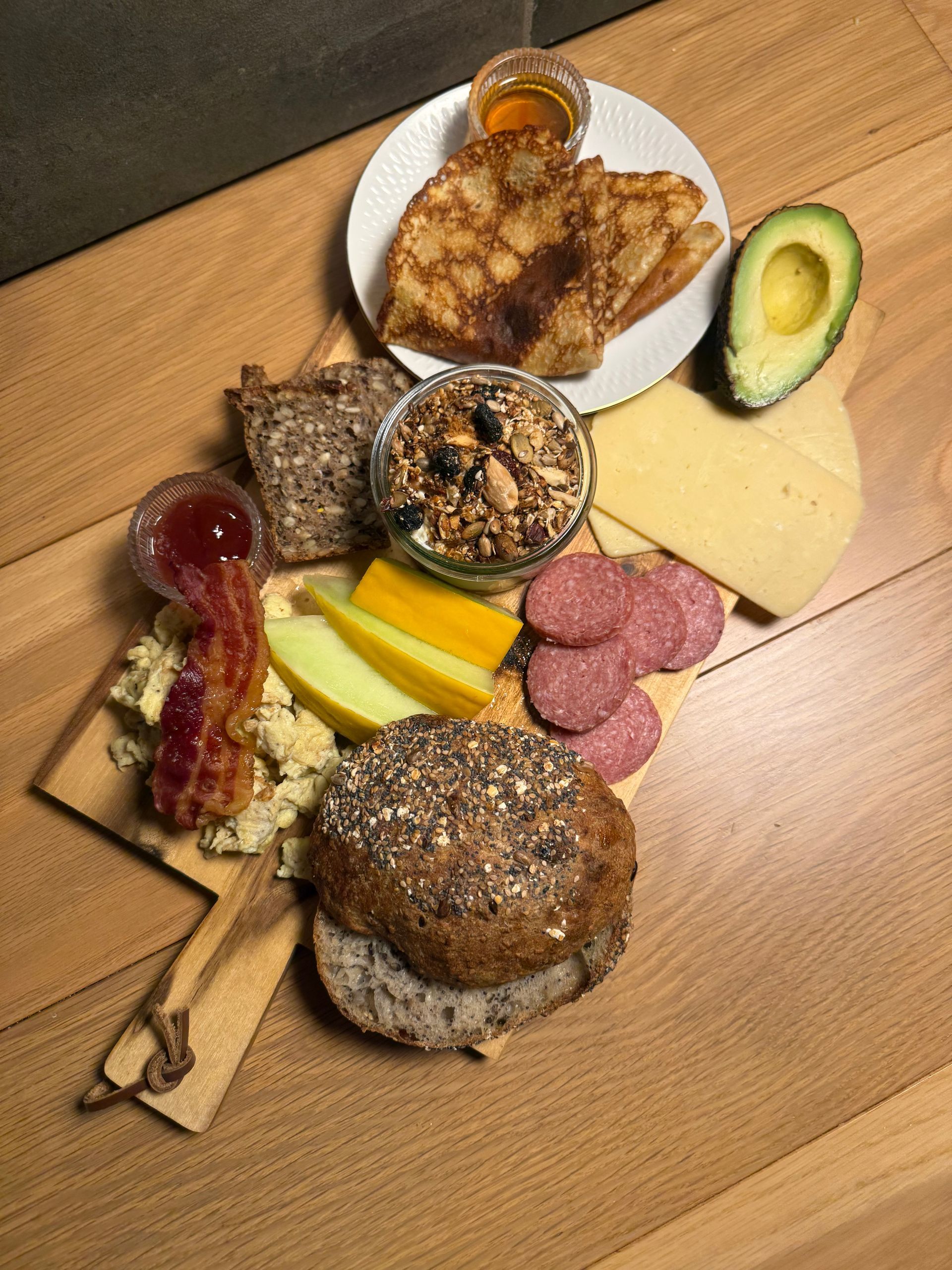 Charcuterie-fad med salami, brød, ost, kiks og dip på en blomsterfad.