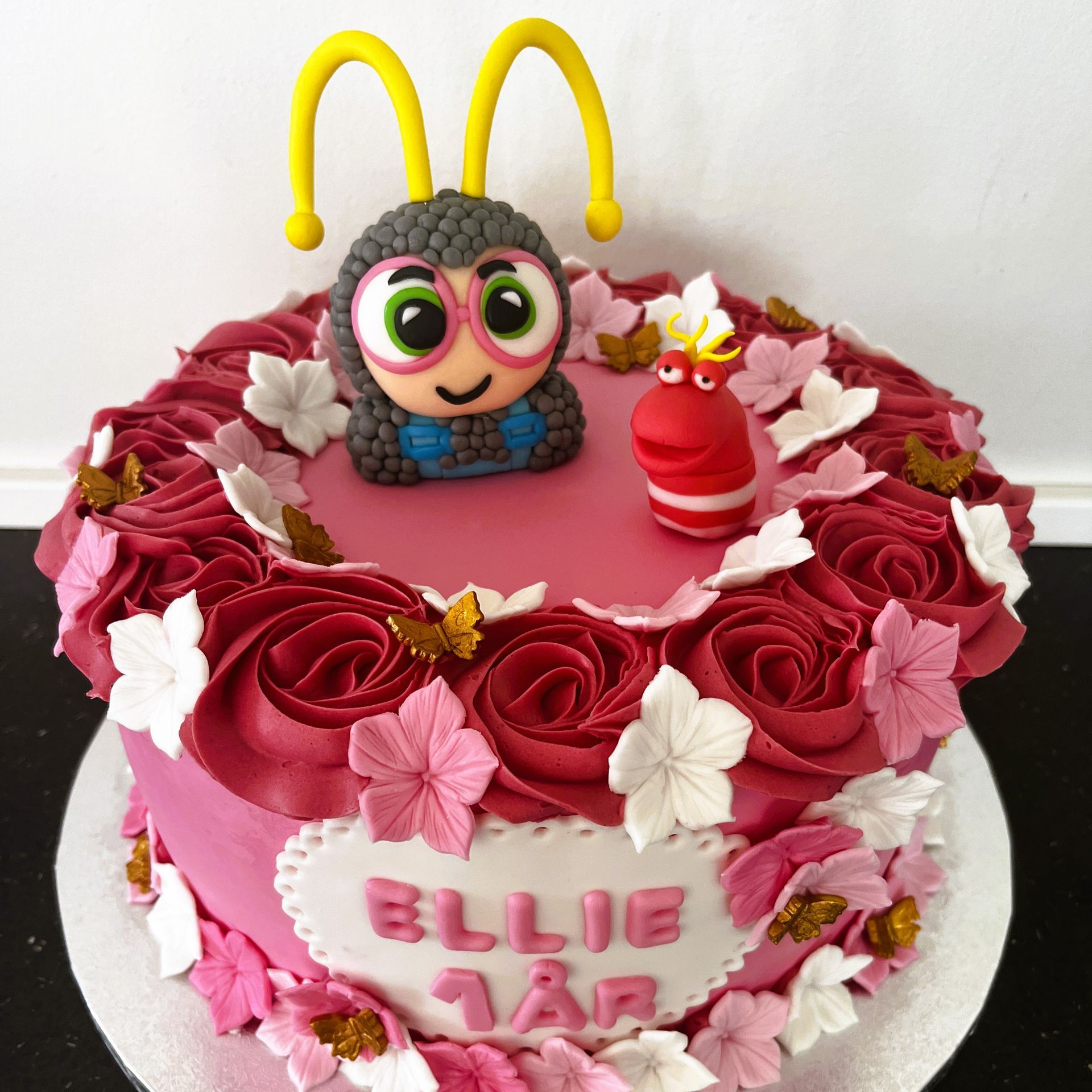 En lyserød kage med navnet Ellie på.