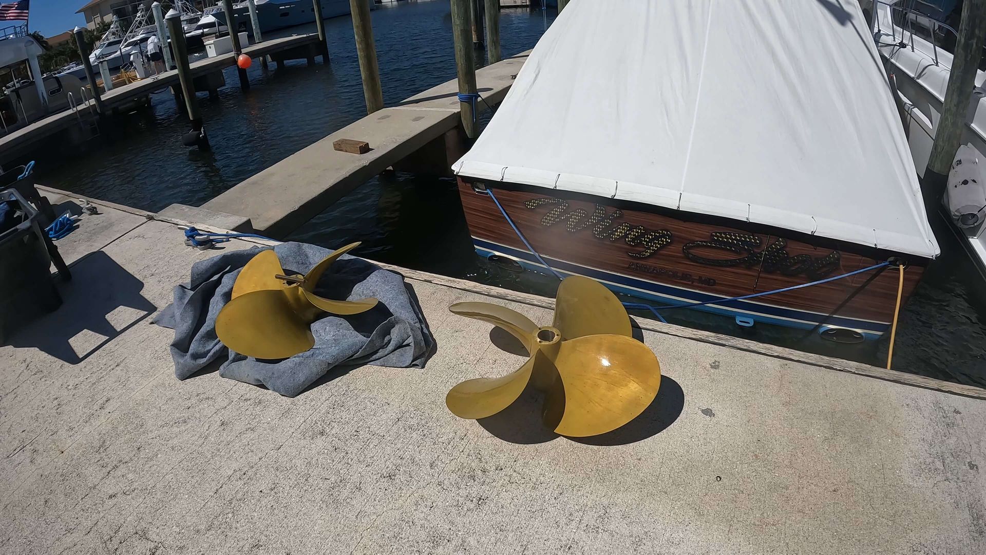 A boat is docked at a dock with two propellers in front of it