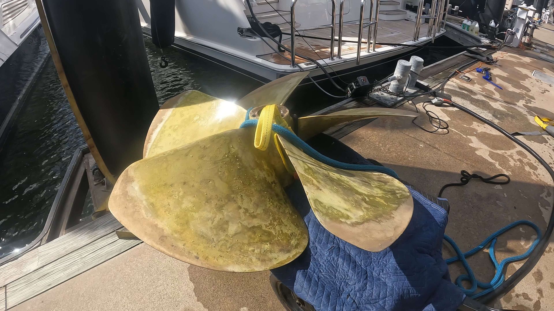 A boat is docked at a dock with two propellers in front of it