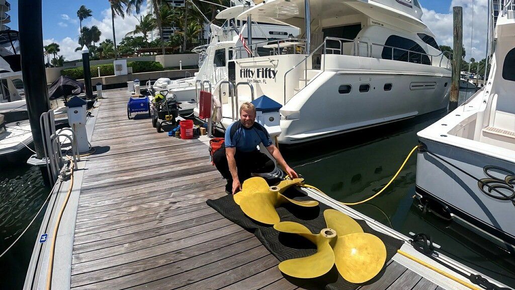 A hull diver shows the four blade propellers he both removed and installed underwater on a 60' Hampton yacht