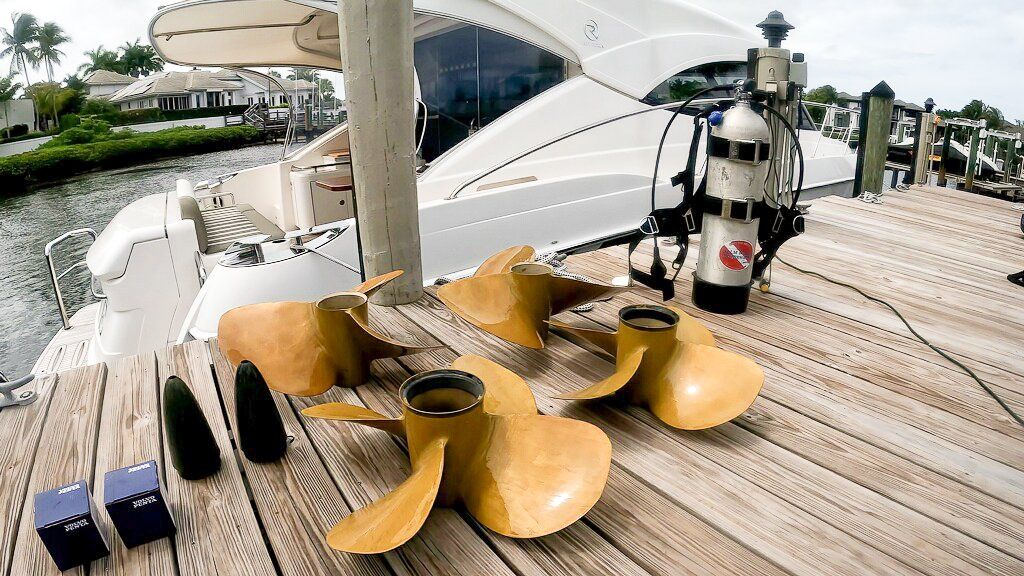 A hull diver shows the set of Volvo Penta IPS propellers he both removed and installed underwater on a 48' Riviera yacht