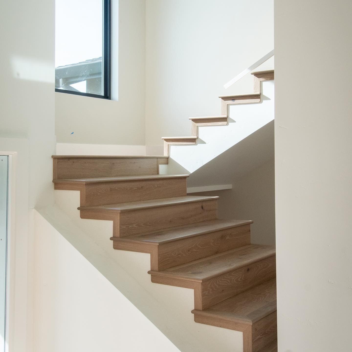 A staircase with wooden steps and white walls