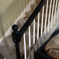 A close up of a black railing on a set of stairs.