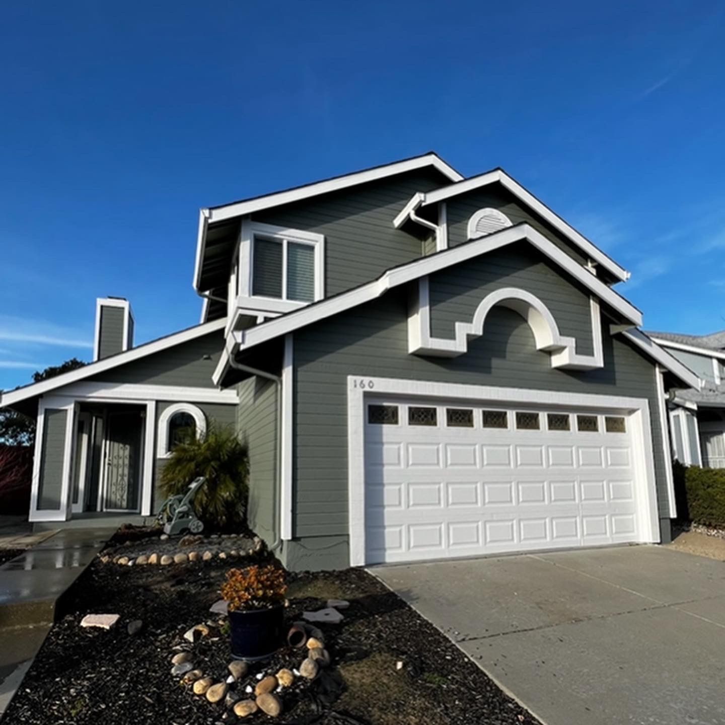 A gray and white house with a white garage door