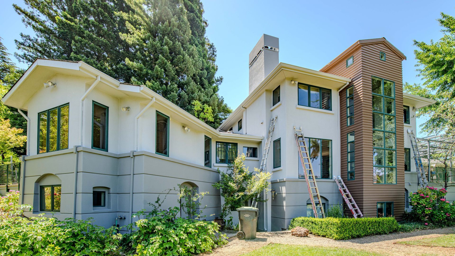 A large white house with a ladder in front of it