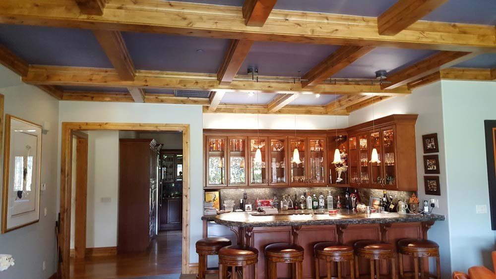A living room with a bar and stools in it