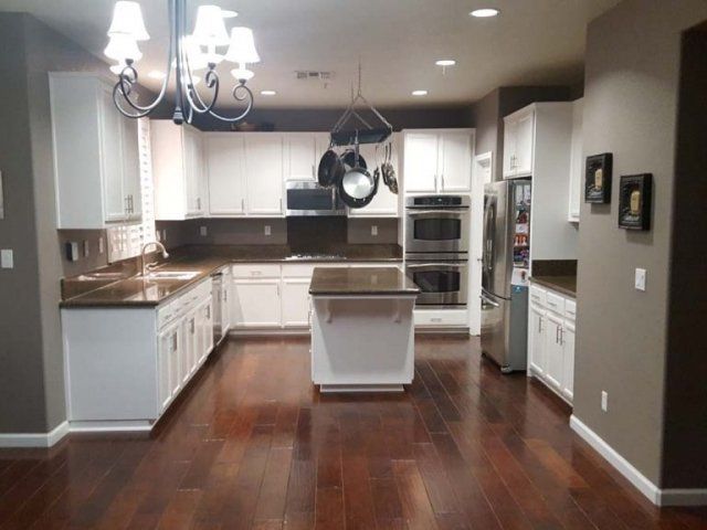 A kitchen with white cabinets and stainless steel appliances
