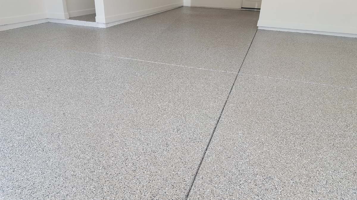 A room with a gray concrete floor and white walls.