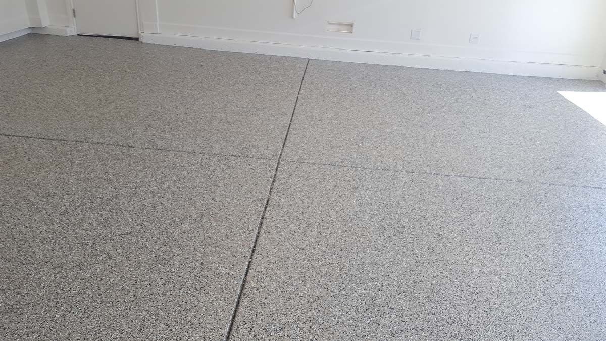 A room with a gray floor and a white wall.