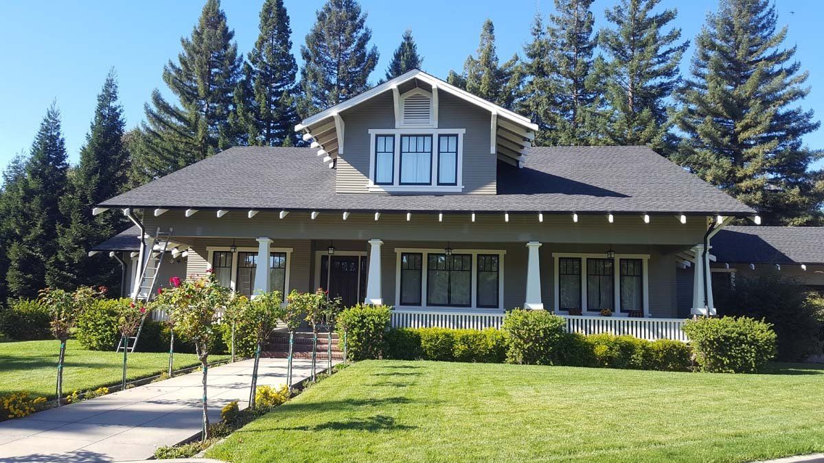 A large house with a gray roof and white trim