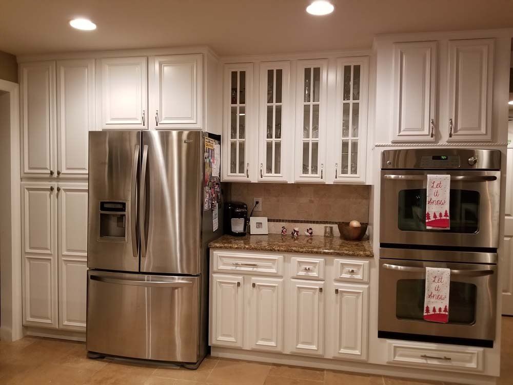 A kitchen with stainless steel appliances and white cabinets.